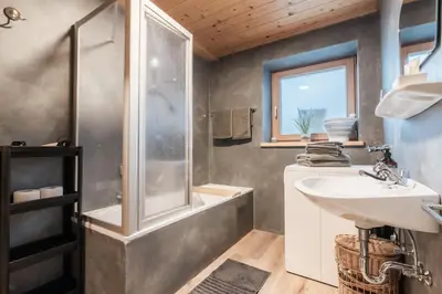 a bathroom with a shower and a sink and a tub at La ciasota in Antermoia