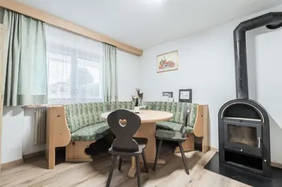 a living room with a table and a wood stove at La ciasota in Antermoia