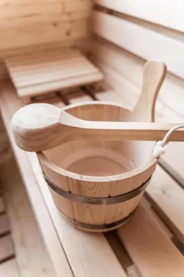 a wooden bowl in a sauna with a wooden spoon at La ciasota in Antermoia