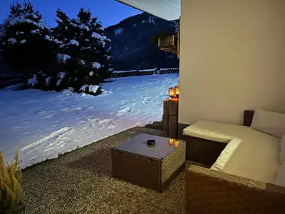 a living room with a couch and a window with snow at La ciasota in Antermoia