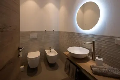 a bathroom with a sink and a toilet and a mirror at Noan Panorama Suiten - Arendt in San Genesio Atesino