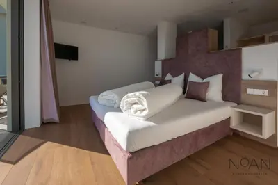 a bedroom with a large bed in a room at Noan Panorama Suiten - Arendt in San Genesio Atesino