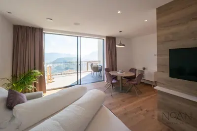 a living room with a white couch and a television at Noan Panorama Suiten - Arendt in San Genesio Atesino