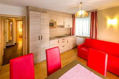 a living room with red chairs and a red couch at Apartments Diamant in Ortisei