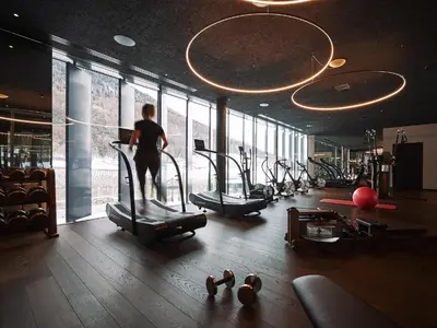 a man is walking on a treadmill in a gym at Manna Resort in Montagna
