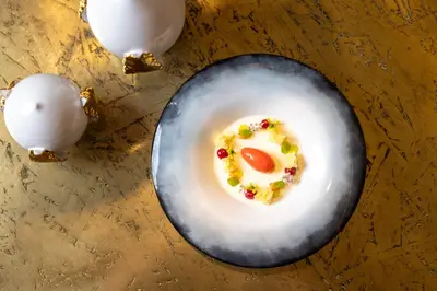 a plate of food with a egg on a table at Manna Resort in Montagna