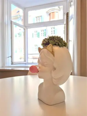 a statue of a woman sticking its tongue at Rosa Apartment with parking historic city center in Merano