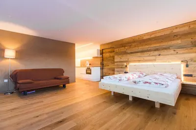 a bedroom with a bed and a chair in it at Zolerhof in Feldthurns