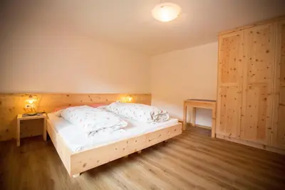 a bedroom with a wooden bed with two pillows at Zolerhof in Feldthurns