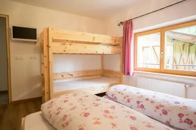 a bedroom with a bunk bed and a window at Zolerhof in Feldthurns