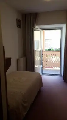 a hotel room with a bed and a large window at Albergo Alpino in Arabba