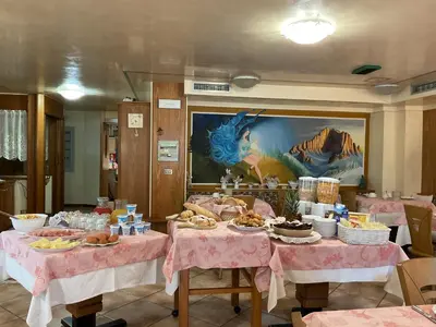 a dining room with two tables with food on them at Albergo Alpino in Arabba