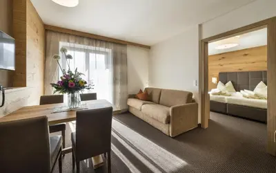 a living room with a couch and a table and a bed at mittendorf klimaresidence in Schenna