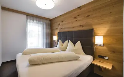 a bedroom with two beds with white pillows at mittendorf klimaresidence in Schenna