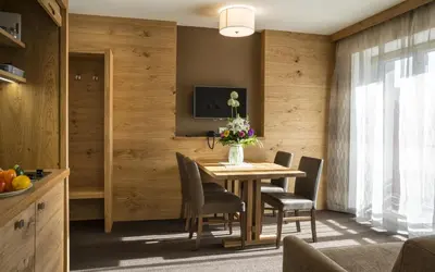 a dining room with a table and chairs and a television at mittendorf klimaresidence in Schenna