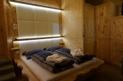a room with a bed with pillows and a light at La Ücia by Fana Ladina in San Vigilio Di Marebbe