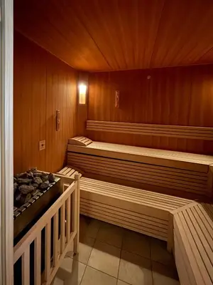 a sauna with two beds and a stove in it at Apartments Ciastel in San Vigilio Di Marebbe