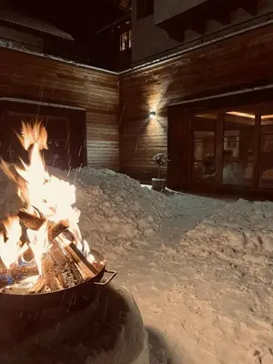 a fire pit in front of a wooden building at Apartments Ciastel in San Vigilio Di Marebbe