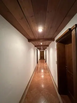 an empty hallway with a ceiling and a door at Panoramic apartment 71 in San Martino di Castrozza