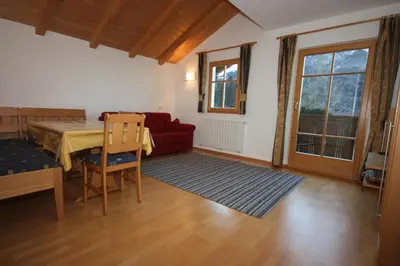a living room with a table and a red couch at Villa Anna in Siusi
