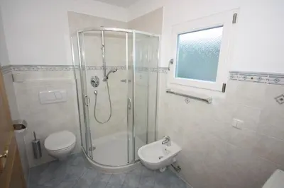 a bathroom with a shower and a toilet and a sink at Villa Anna in Siusi
