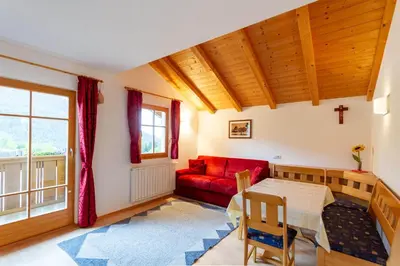 a living room with a red couch and a table at Villa Anna in Siusi