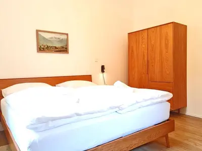 a bedroom with two beds and a wooden cabinet at Apartment Emilie with parking historic city center in Merano