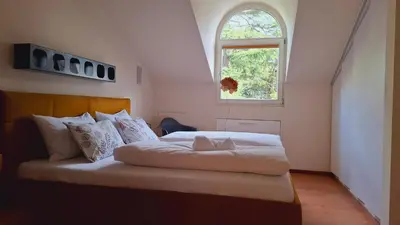 a bedroom with two beds and a blue rug at Mansarde Zeder in Privatvilla im Zentrum Merans in Merano