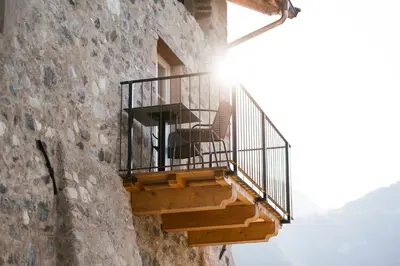 a balcony on the side of a stone building at St. Vigilius modern historic apartments in Nalles