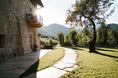 a stone walkway next to a building with a tree at St. Vigilius modern historic apartments in Nalles