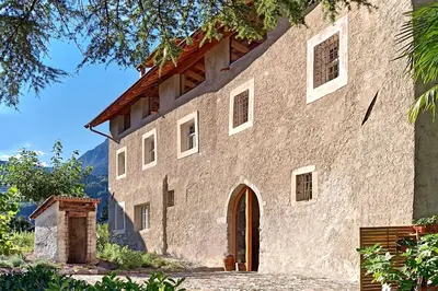an external view of a large stone building at St. Vigilius modern historic apartments in Nalles