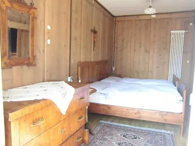 a bedroom with a bed and a dresser at Casa Sartori in Tesero