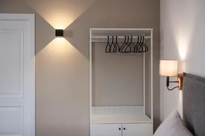 a bedroom with a mirror and a light on the wall at Brixen City Maisonette in Bressanone