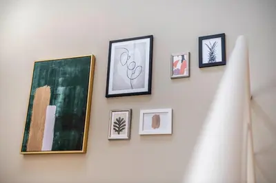 a wall with framed pictures on a wall at Brixen City Maisonette in Bressanone
