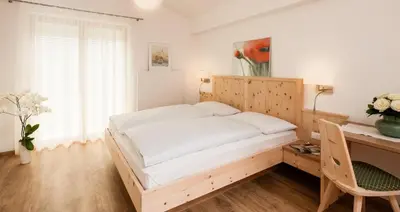 a bedroom with a bed and a desk and a desk at Garni Appartment Wagnerhof in Rablà