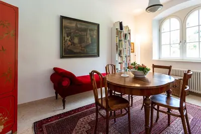 a dining room with a table and a red couch at Appartement im Grünweinhof in Montagna