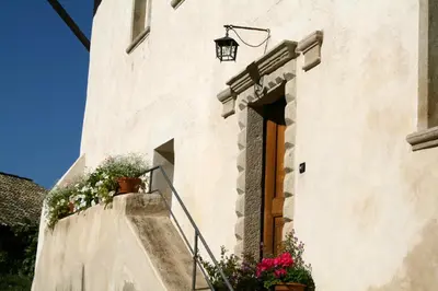 a white building with flowers on the stairs at Appartement im Grünweinhof in Montagna
