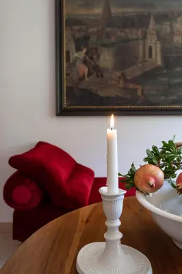 a candle sitting on a table with a bowl of fruit at Appartement im Grünweinhof in Montagna