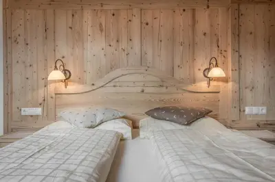two beds in a room with wooden walls at B&B Ciastel in San Vigilio Di Marebbe
