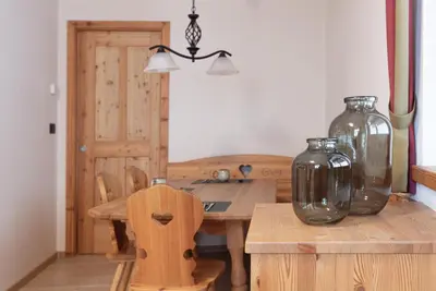 a dining room with a wooden table and vases at Chalet Tyrolian Apartments - by Familiaris - Pools 500 meters in Valdaora