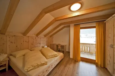 a bedroom with a bed and a large window at Bartlmairhof in San Giorgio