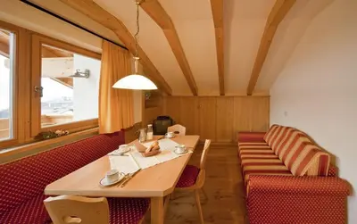 a dining room with a table and red chairs at Bartlmairhof in San Giorgio