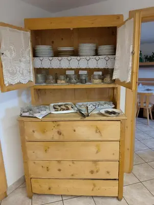 a wooden cabinet with plates and dishes in it at Garni Hattlerhof B&B in Brunico