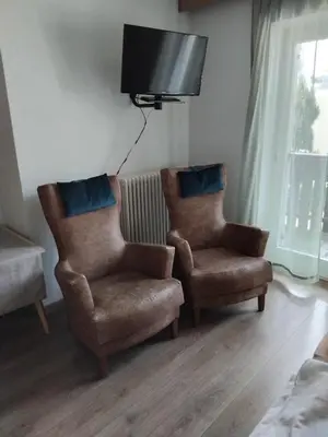 two chairs and a couch in a living room at Garni Hattlerhof B&B in Brunico