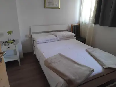 a small bedroom with two beds and a table at Garni Hattlerhof B&B in Brunico