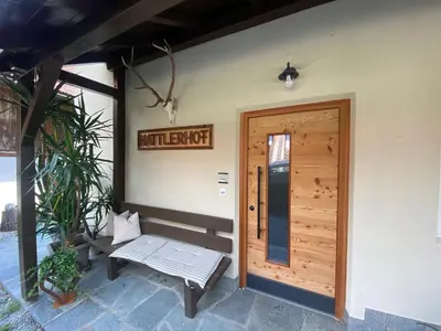 a porch of a house with a door and a bench at Garni Hattlerhof B&B in Brunico
