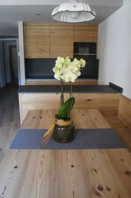 a vase with flowers sitting on a wooden table at Apartment Al Sasso in Taibon