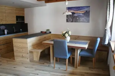 a kitchen with a wooden table and blue chairs at Apartment Al Sasso in Taibon