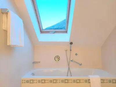 a bathroom with a bath tub with a window at Residence Zum Theater in Colle Isarco