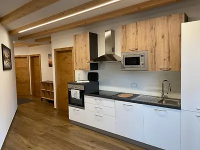 a kitchen with white cabinets and a microwave at Kröllhof in Vallarga